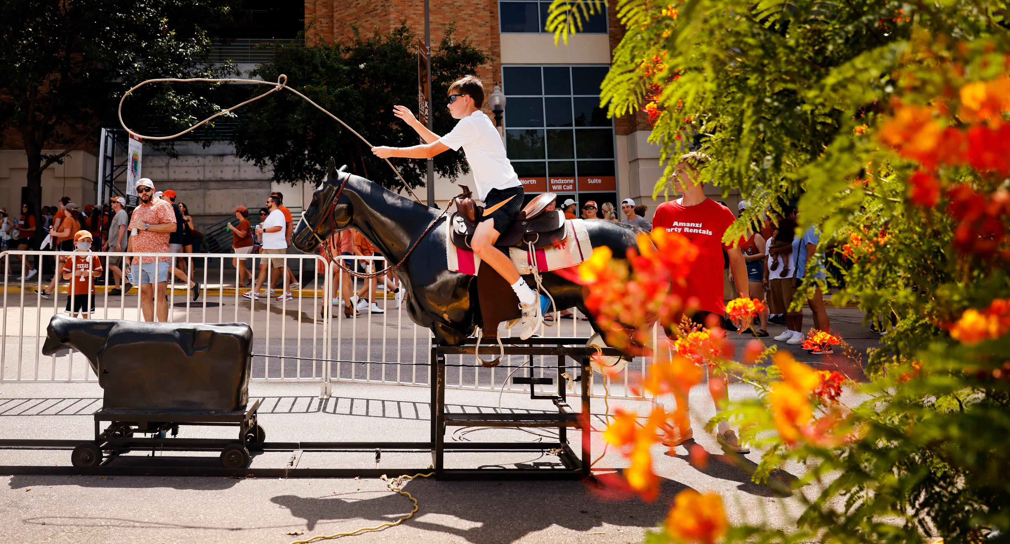 Gavin Thornfield of Dallas tries to lasso a mechanical calf on Smokey's Midway, a mini...