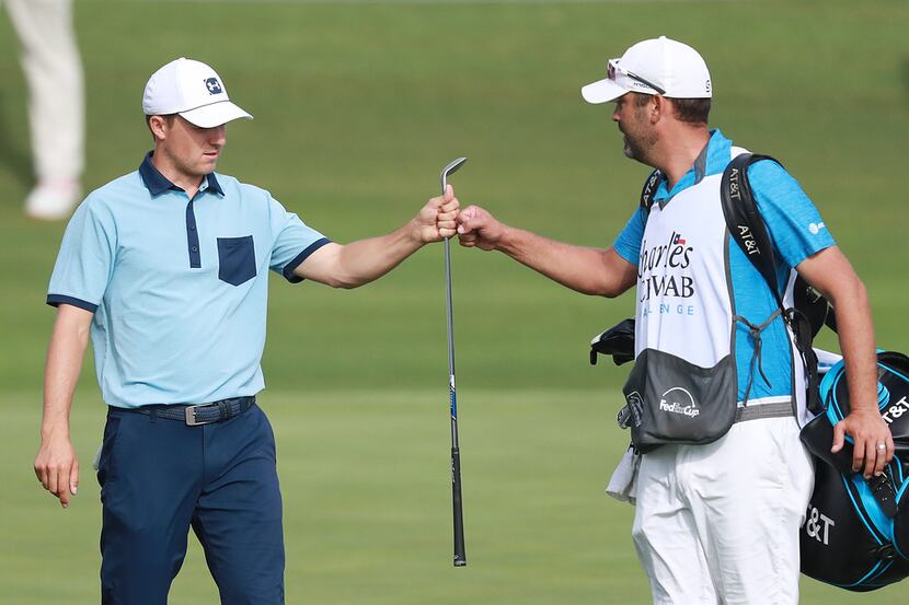 Jordan Spieth of the United States celebrates with caddie, Michael Greller, after a birdie...