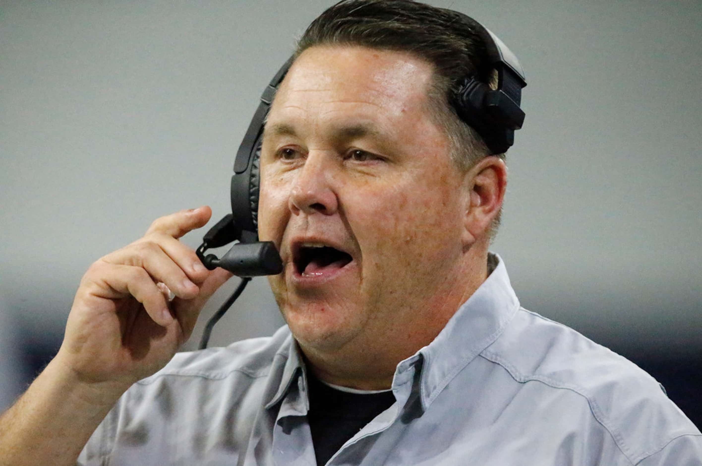 Rockwall High School head coach Rodney Webb talks on his headset during the first half as...