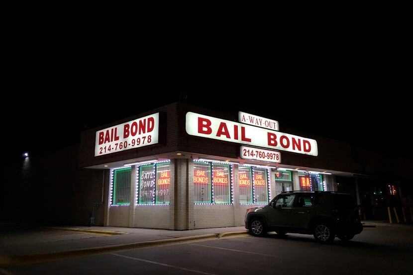 Lights from a bail bond business glow along Riverfront Boulevard in Dallas.