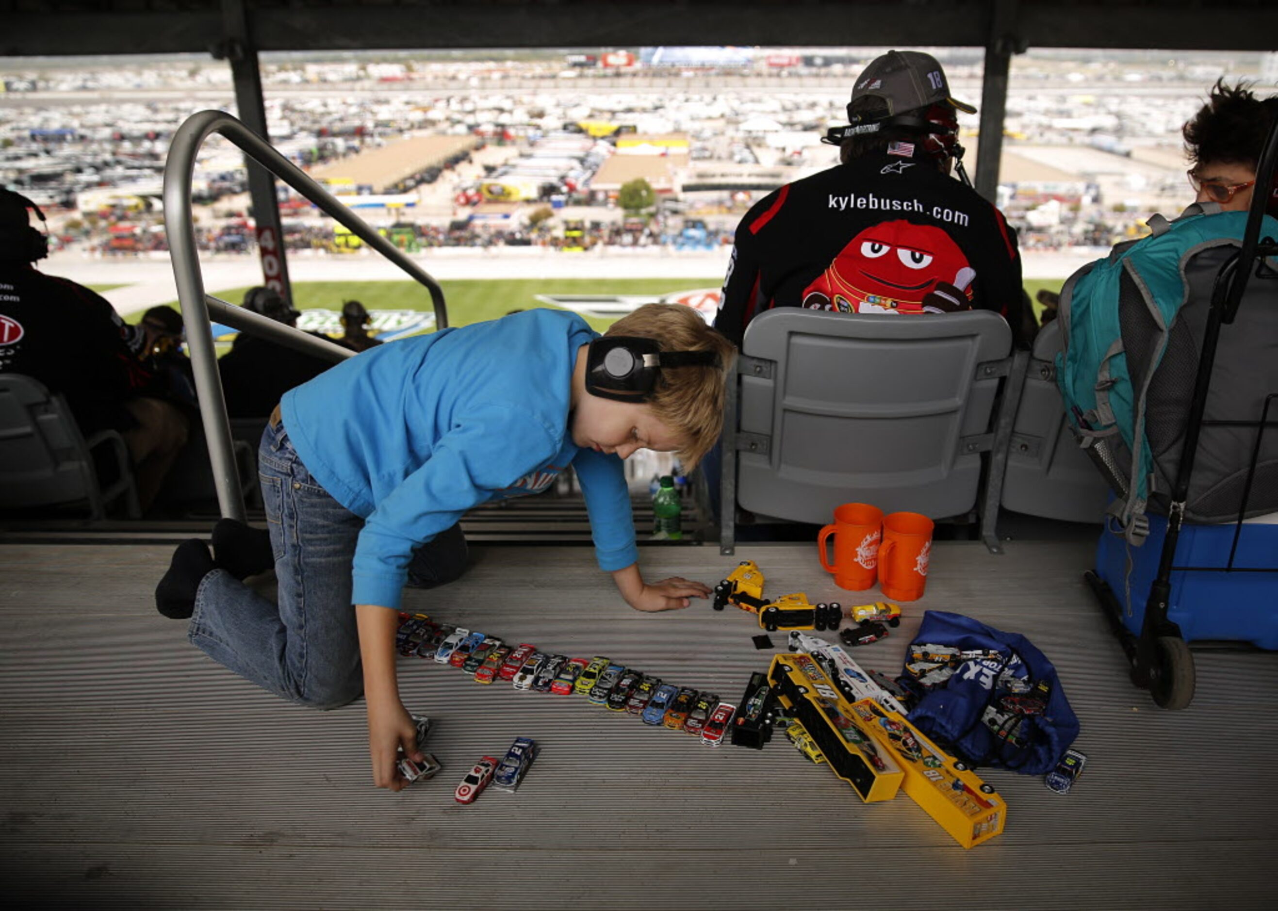 A young boy plays with his stick car collection during the AAA Texas 500 at the Texas Motor...