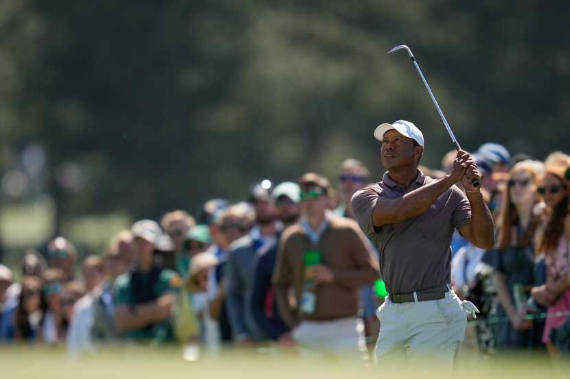 Tiger Woods watches his chip on the 18th hole during second round at the Masters golf...