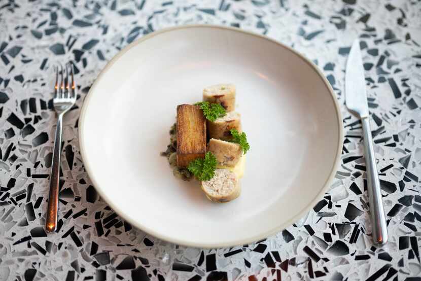 À Gomes de Sá, a shrimp and bacalao sausage with potato pave, confit yolk and pickled ramps,...