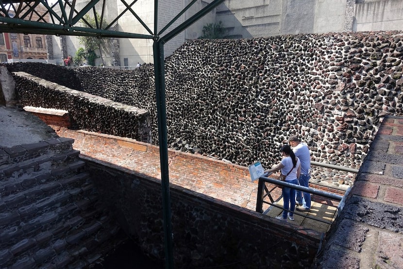 In this July 28, 2016 photo,tourists read an information plaque among the pyramid ruins at...