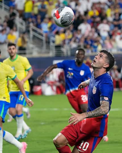 U.S. forward Christian Pulisic looks to control an overhead pass as he moves to the goal...