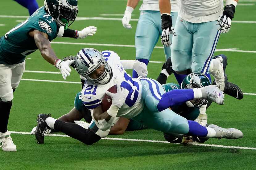 El corredor de los Cowboys de Dallas, Ezekiel Elliott, es detenido por un defensivo de los...