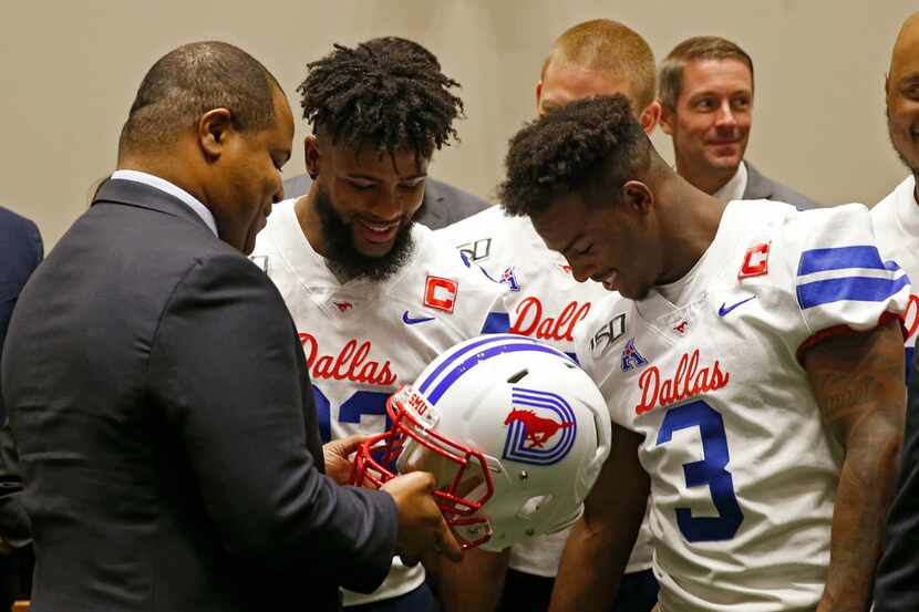 Dallas Mayor Eric Johnson takes a look at the newly designed SMU football helmet with...
