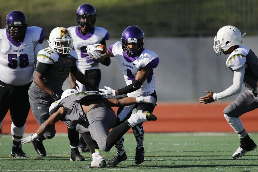 Lincoln's Devodric Bynum carries the ball during the Madison vs. Lincoln game at Kincaide...