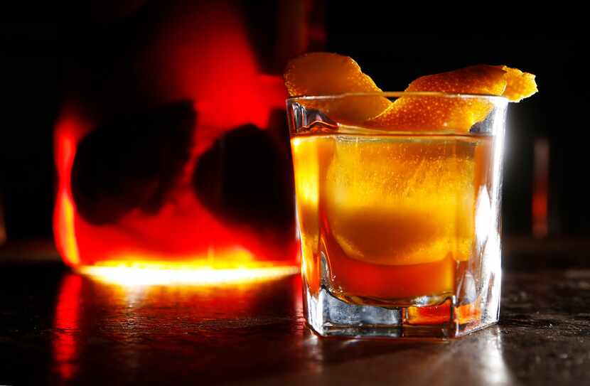 Charred Orange Old Fashioned, an infused cocktail made with a charred orange infused bourbon...