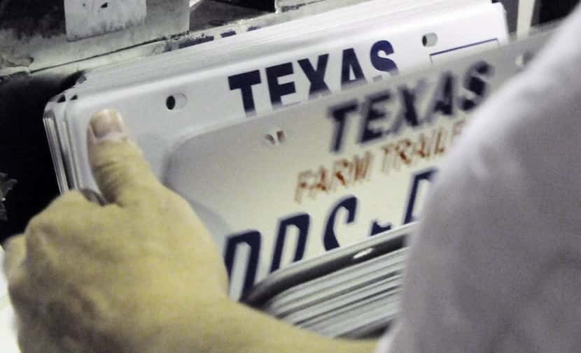 An inmate inspects a stack of new Texas license plates at the Wynne Farm Unit of the Texas...