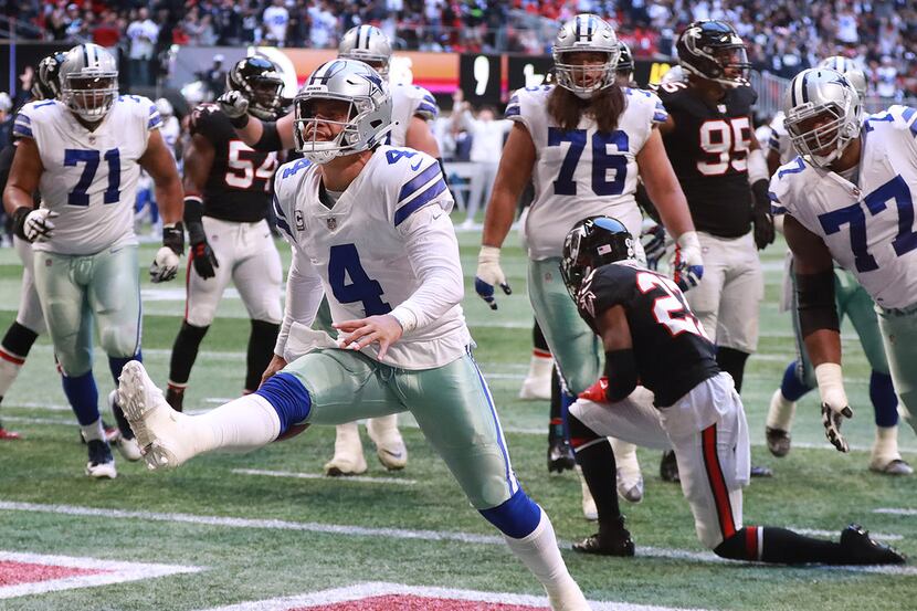 Dallas Cowboys quarterback Dak Prescott reacts to scoring a touchdown on a quarterback...