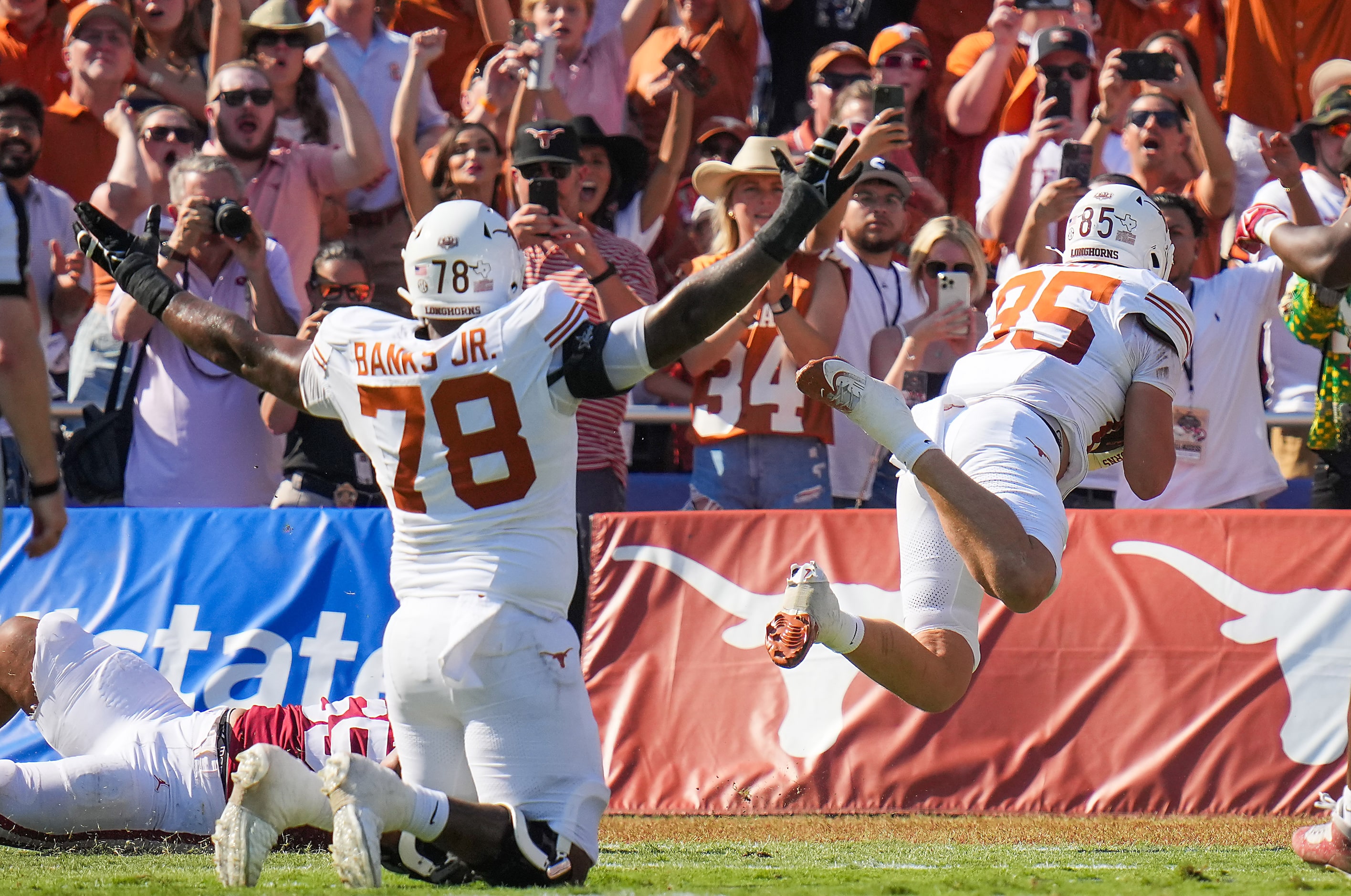 Texas offensive lineman Kelvin Banks Jr. (78) celebrates as tight end Gunnar Helm (85) dives...