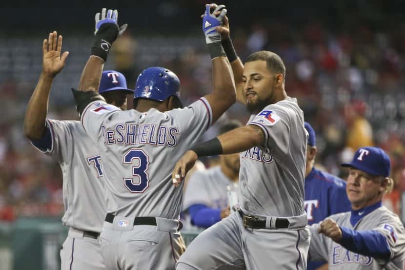 Texas Rangers' Rougned Odor greets Delino DeShields after DeShields scored in their...