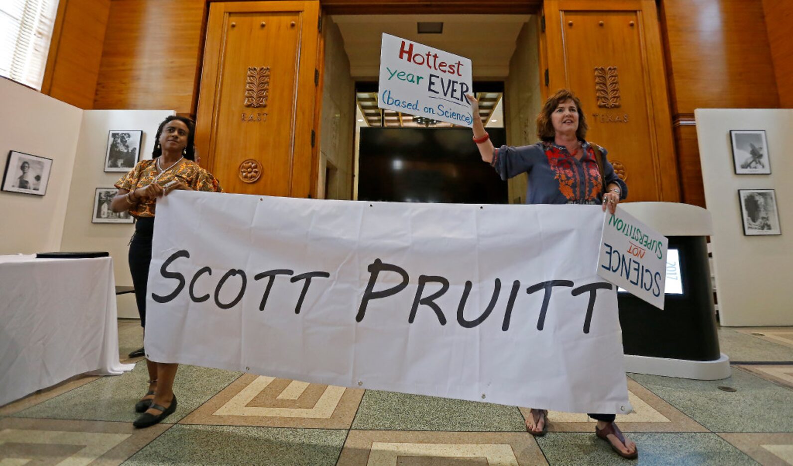 Protesters Cherelle Blazer (left) and Danna Miller Pyke hold a banner inside the Hall of...