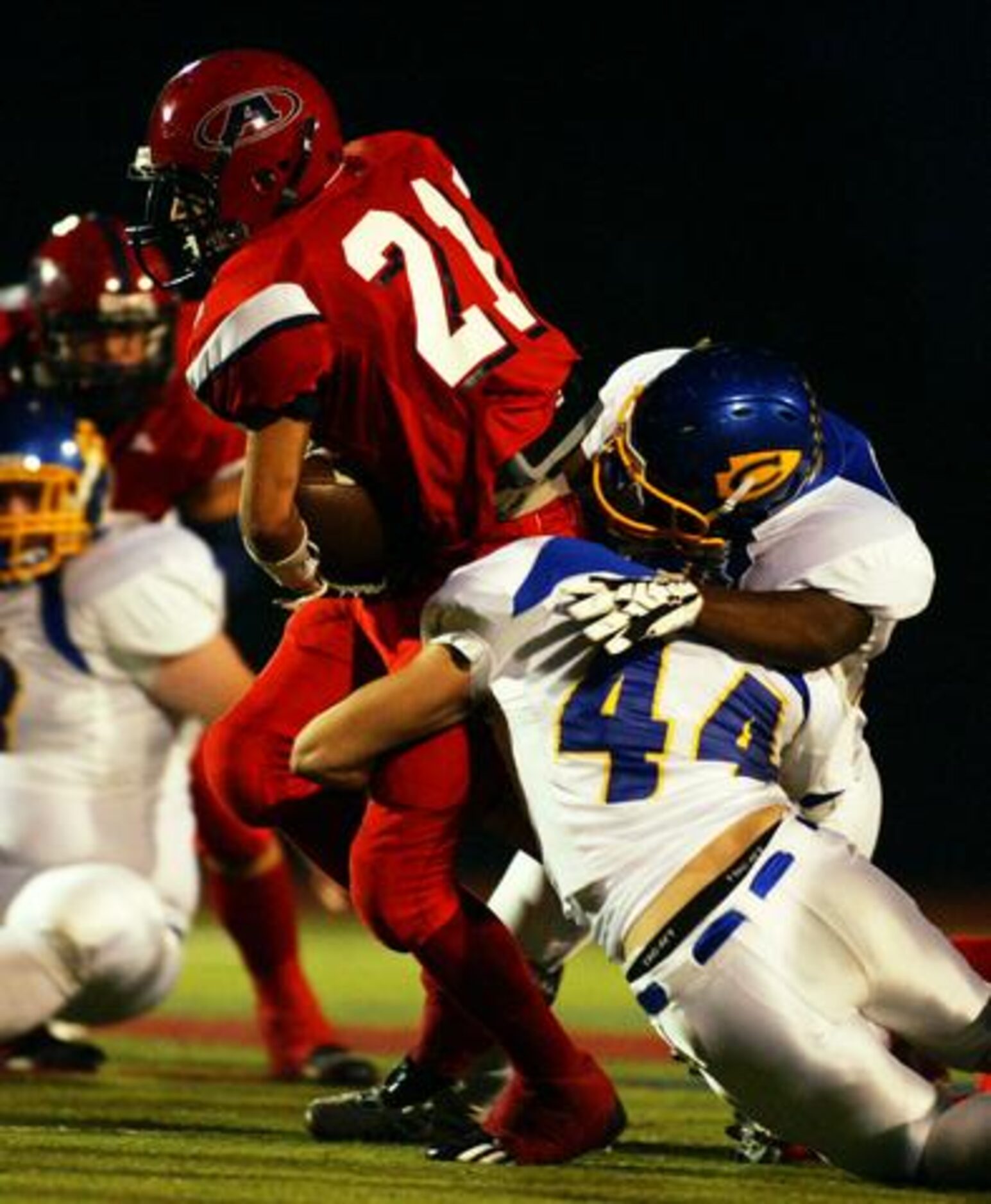 Aubrey's Chase Mahurin (21) is tackled by Nevada Community senior linebackers Troy Graves...