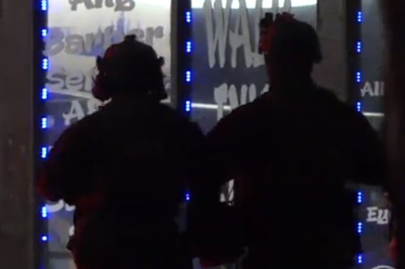 Fort Worth SWAT officers stand outside a business where a woman with a gun was inside and...