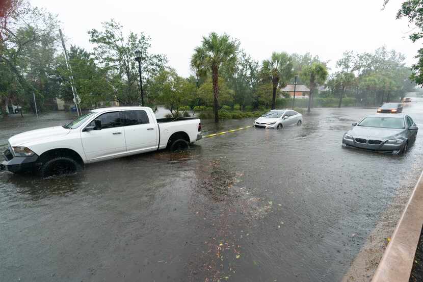 A good Samaritan pulls a stuck motorists from the high water during the effects from...