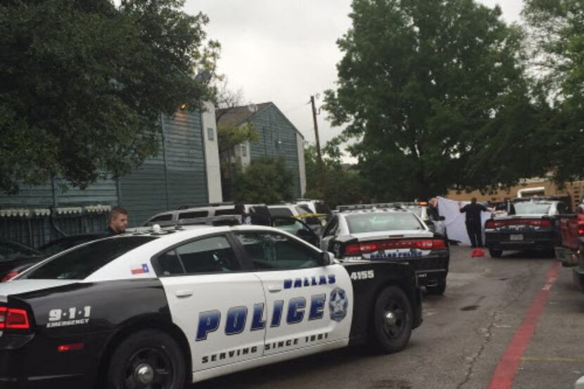 
Dallas police held up a sheet as they removed the body from a car at the Winding Way...
