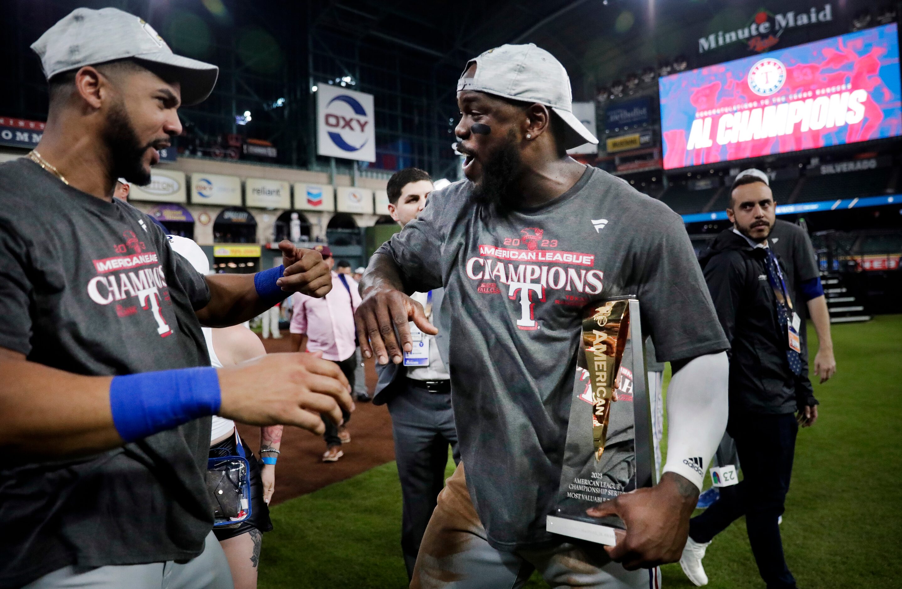 Texas Rangers right fielder Adolis Garcia (right) celebrates with his MVP trophy with center...