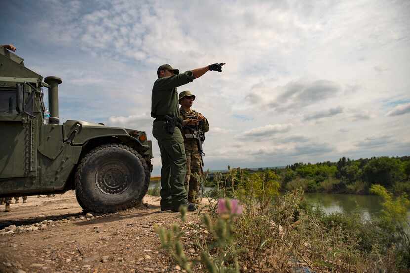 A Border Patrol officer talked with a member of the Texas National Guard along the Rio...