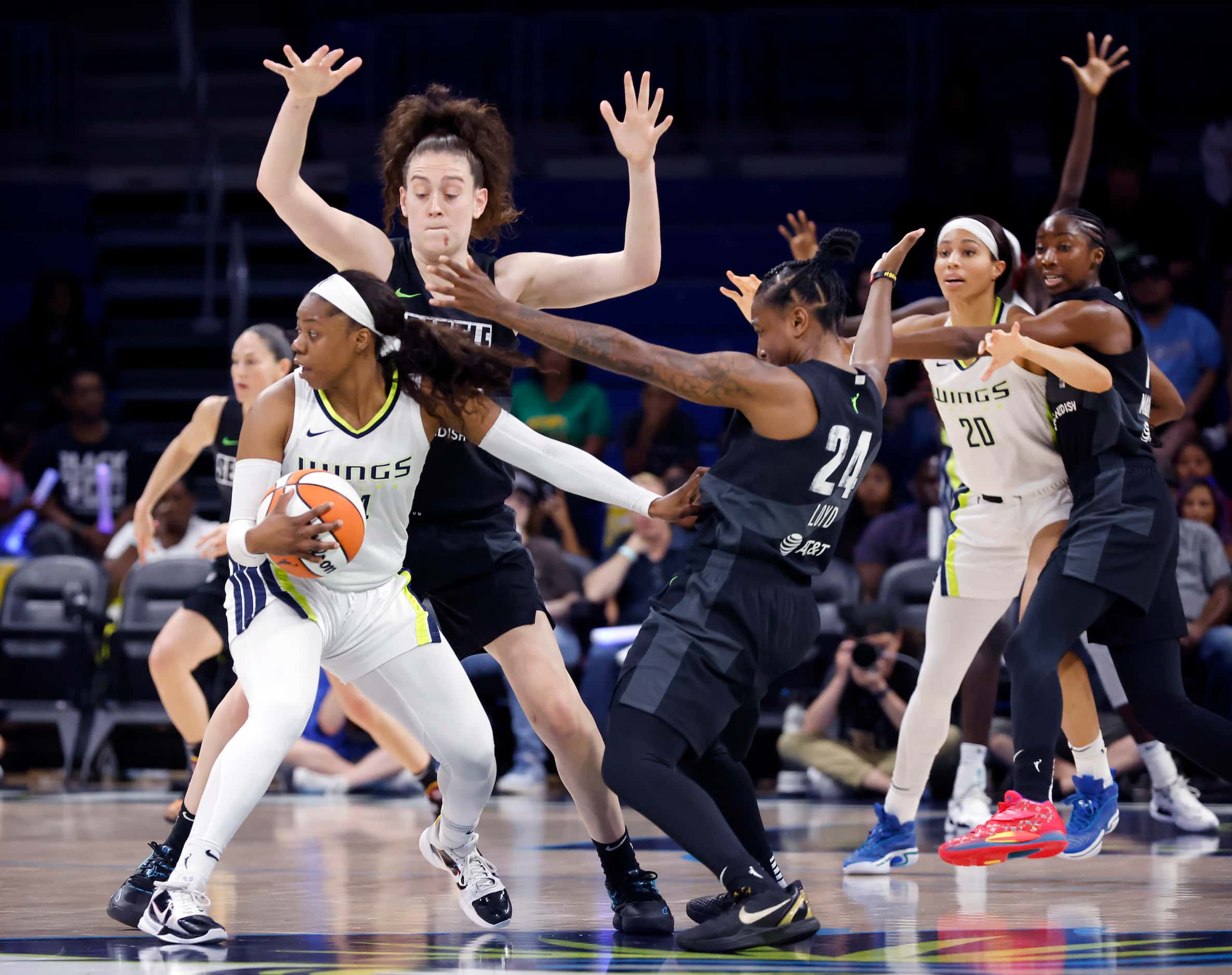 Dallas Wings guard Arike Ogunbowale (24) tries to spin out of double coverage by Seattle...