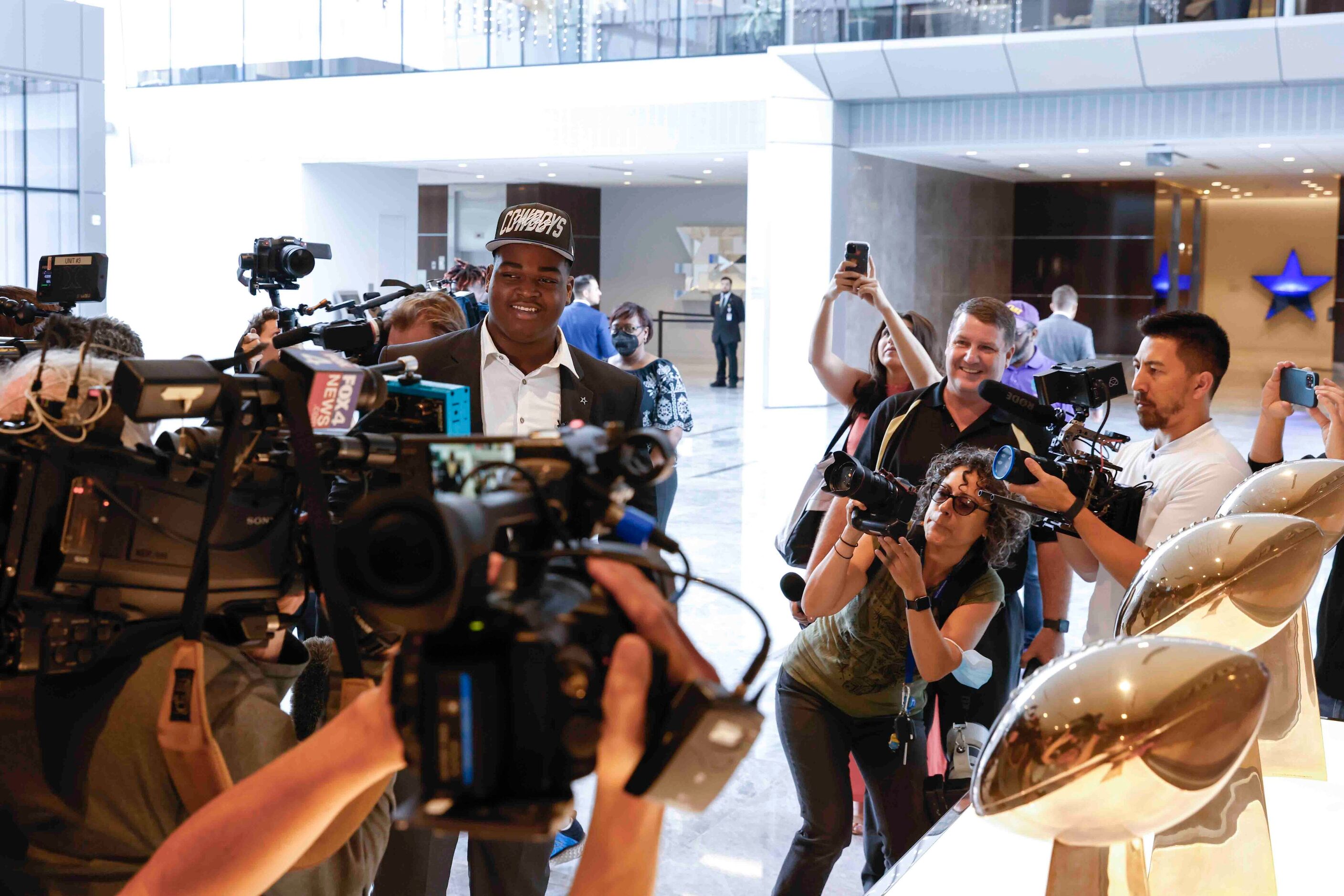 Members of the media surrounds Dallas Cowboys first round draft pick Tyler Smith of Tulsa as...