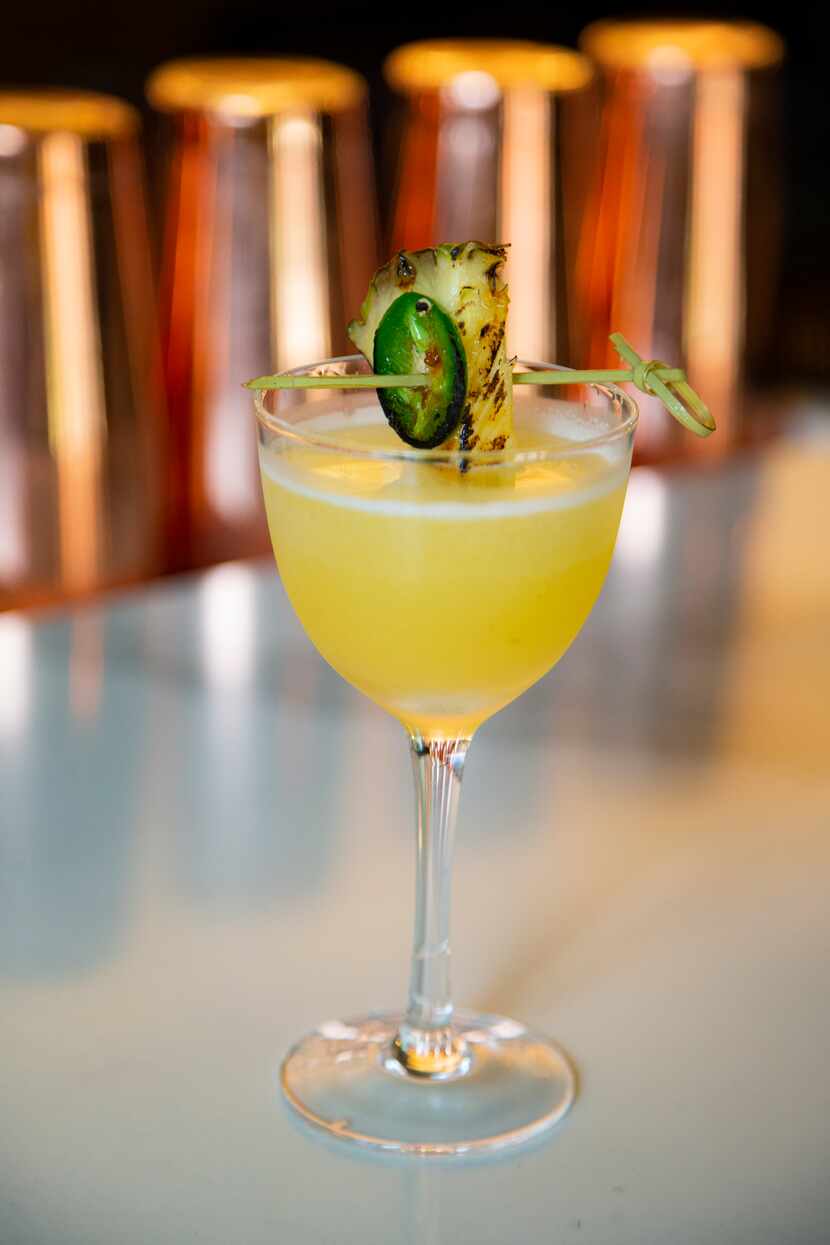 An “Alli Dee” cocktail, made primarily with tequila, pineapple and lime juice garnished with...