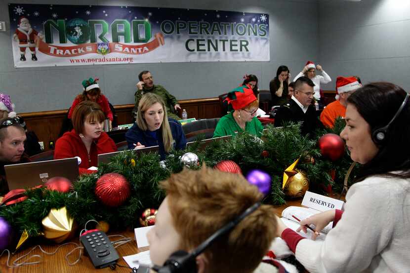 FILE - In this Dec. 24, 2012 file photo, volunteers take phone calls from children asking...