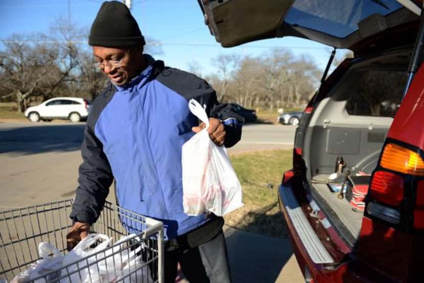 
Gregory George loads groceries into his vehicle at the Cedar Hill Food Pantry on Jan. 3,...