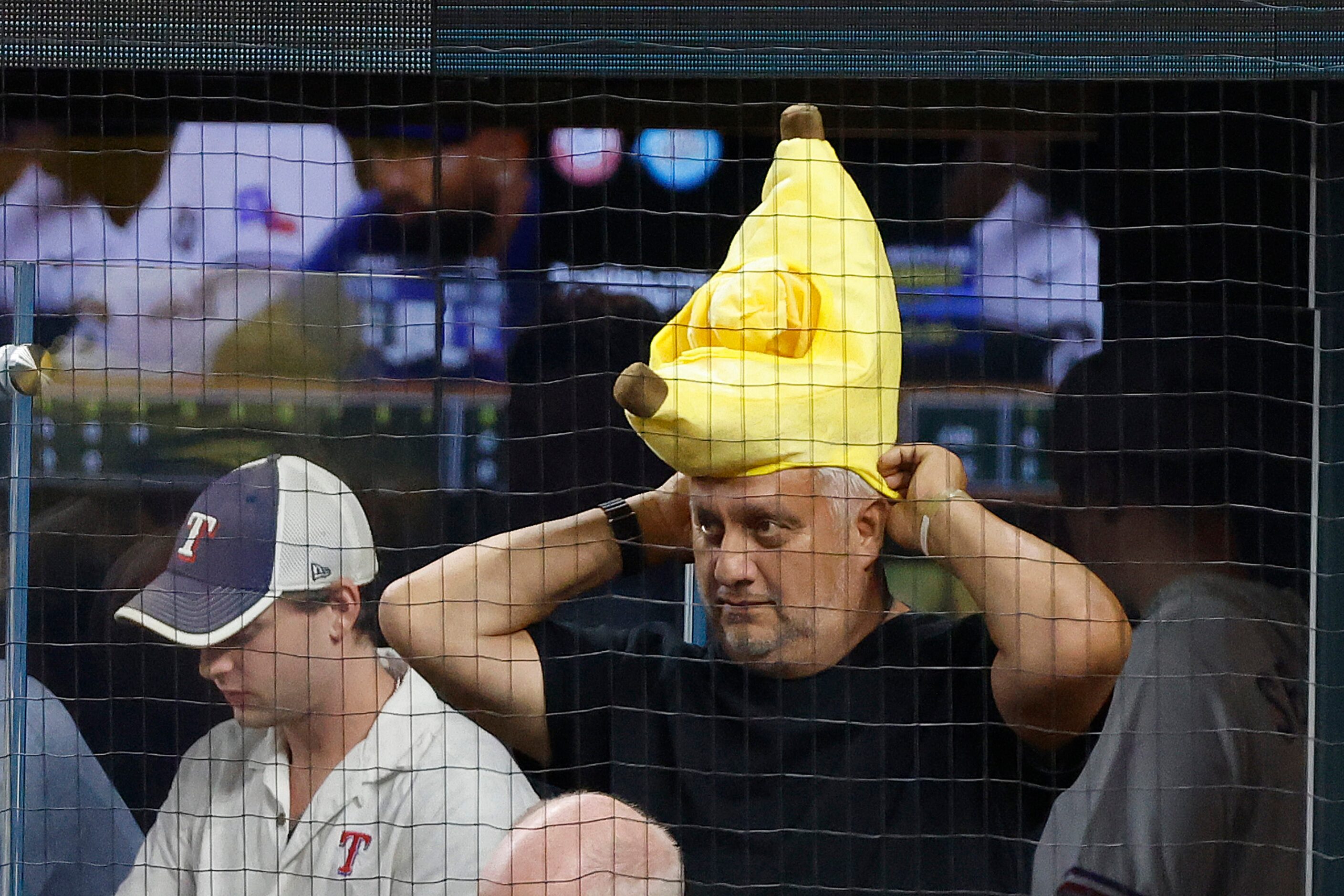 A fan puts on a banana hat behind home plate during Game 2 of the World Series between the...