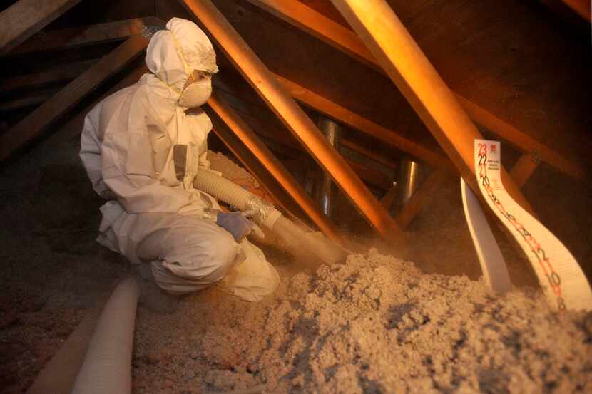 
A worker adds insulation to an attic in Colorado, another improvement questioned by a...