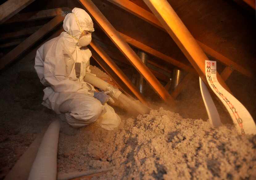 
A worker adds insulation to an attic in Colorado, another improvement questioned by a...