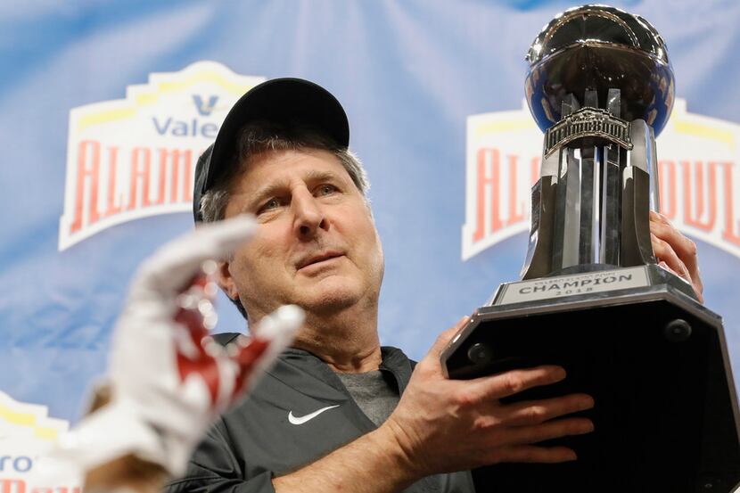 SAN ANTONIO, TX - DECEMBER 28:  Head coach Mike Leach of the Washington State Cougars  holds...