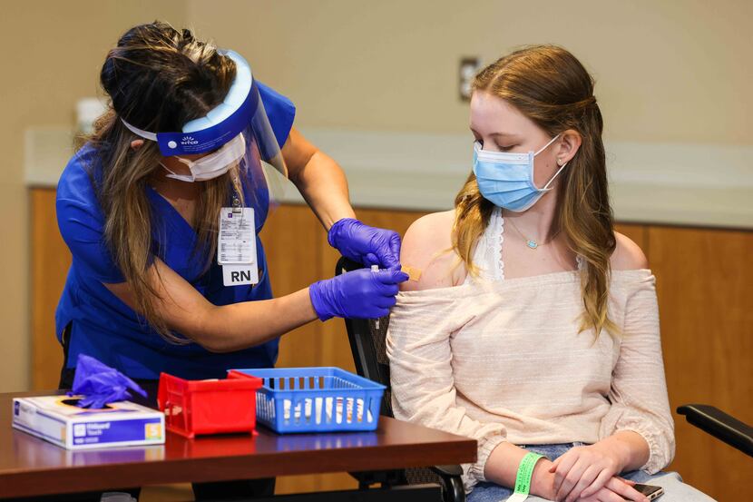 Madeleine Jenkins, 15, Judge Clay Jenkins' daughter, receives a COVID-19 vaccine as the...