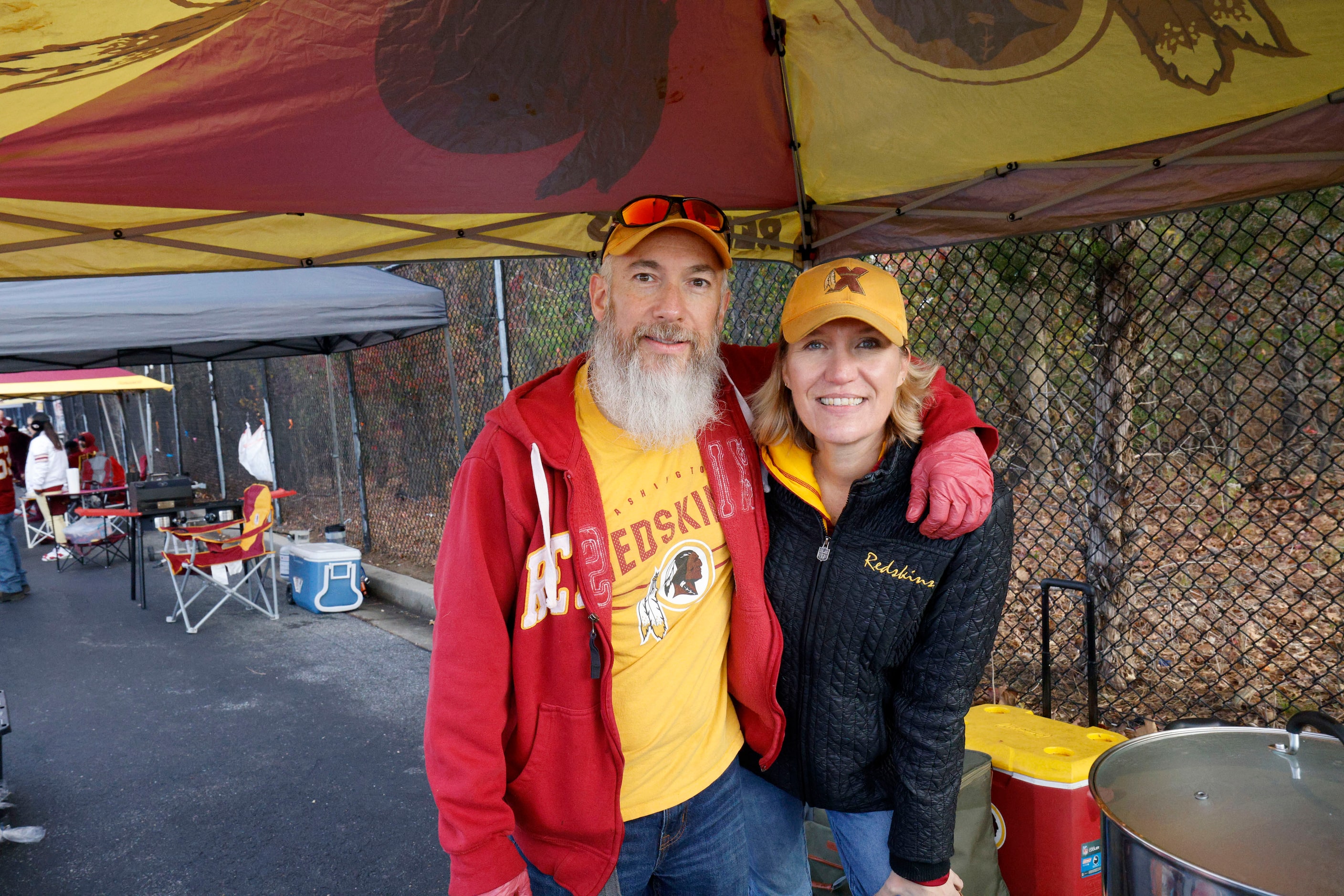 Chris Lopez of Virginia and his wife Christie Lopez pose for a photo while tailgating before...