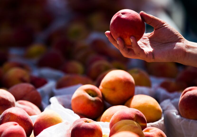People choose peaches during the Parker County Peach Festival in downtown Weatherford.