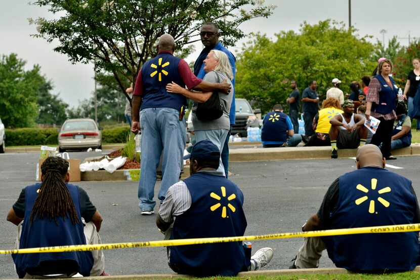 ARCHIVO - En esta foto del 30 de julio de 2019, empleados de Walmart se reúnen en una playa...