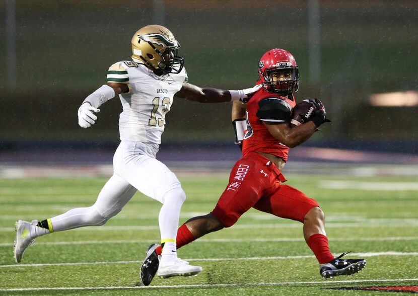 Cedar Hill's Kaegun Williams (24) attempts to break away from DeSoto's Isaiah Stewart (13)...