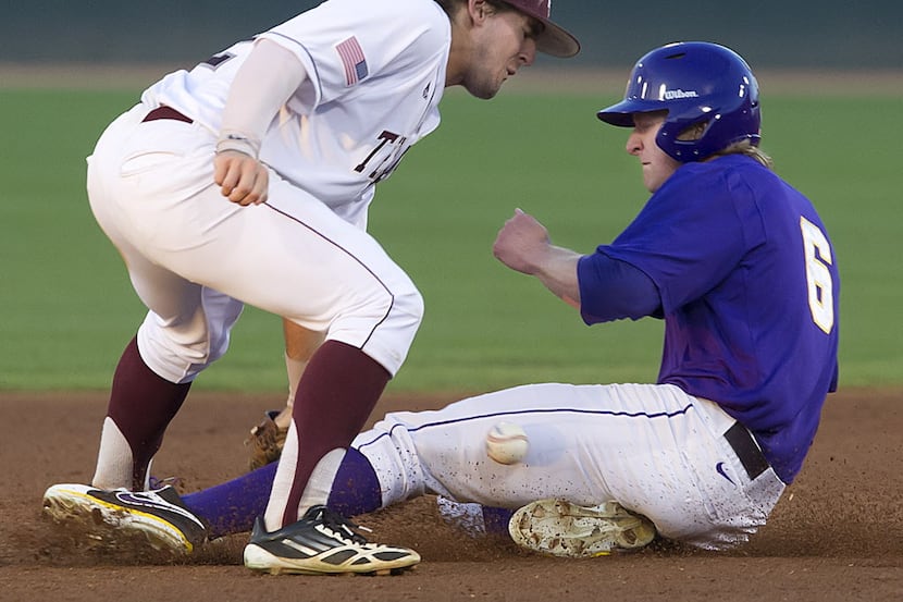 The ball hits LSU's Andrew Stevenson on the leg as he slides safely into second past Texas...