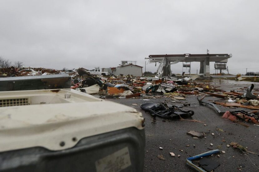 
Debris surrounds a gas station where two deaths were reported at the intersection of State...