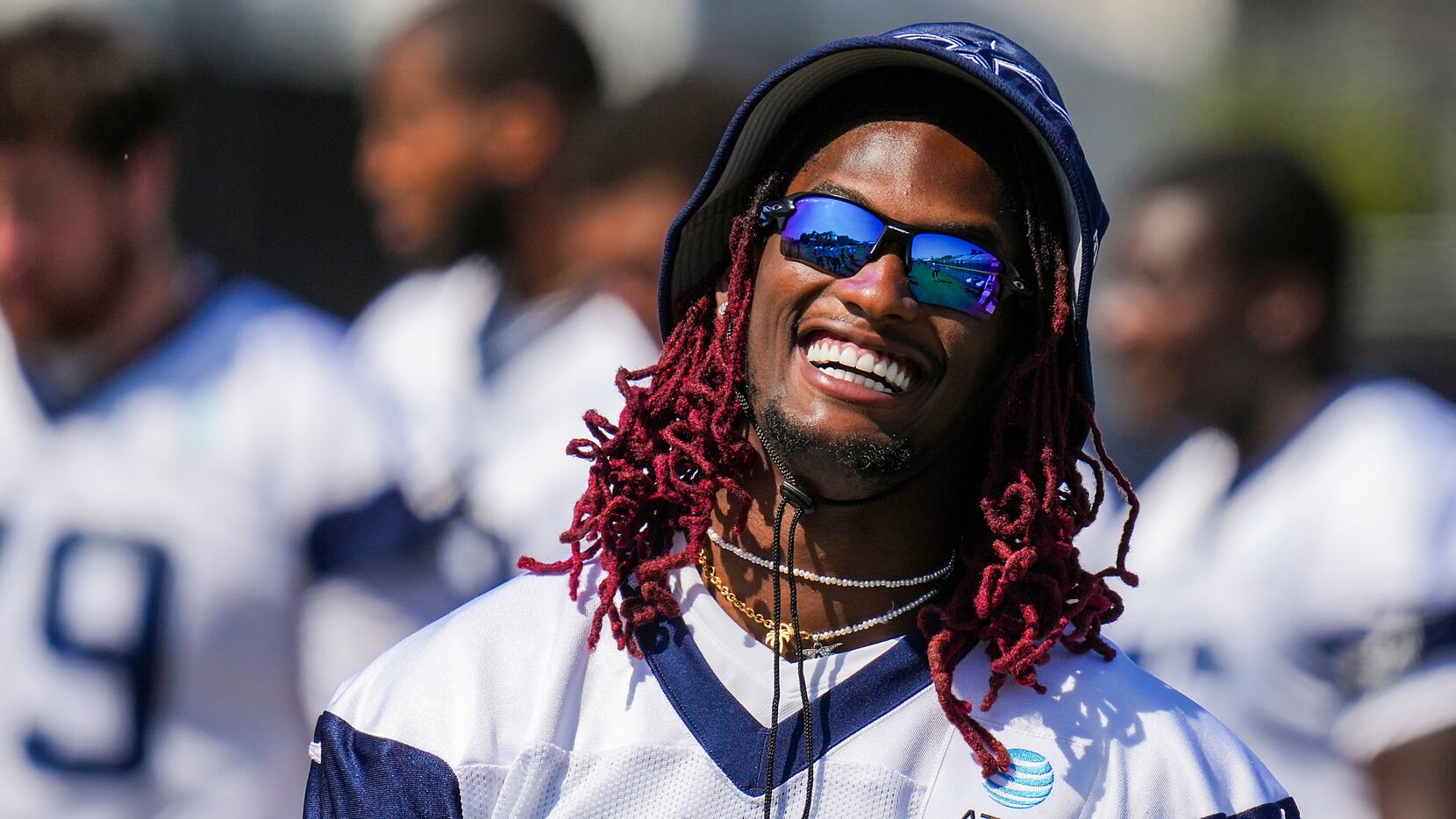 Dallas Cowboys wide receiver CeeDee Lamb laughs with teammates during a training camp...