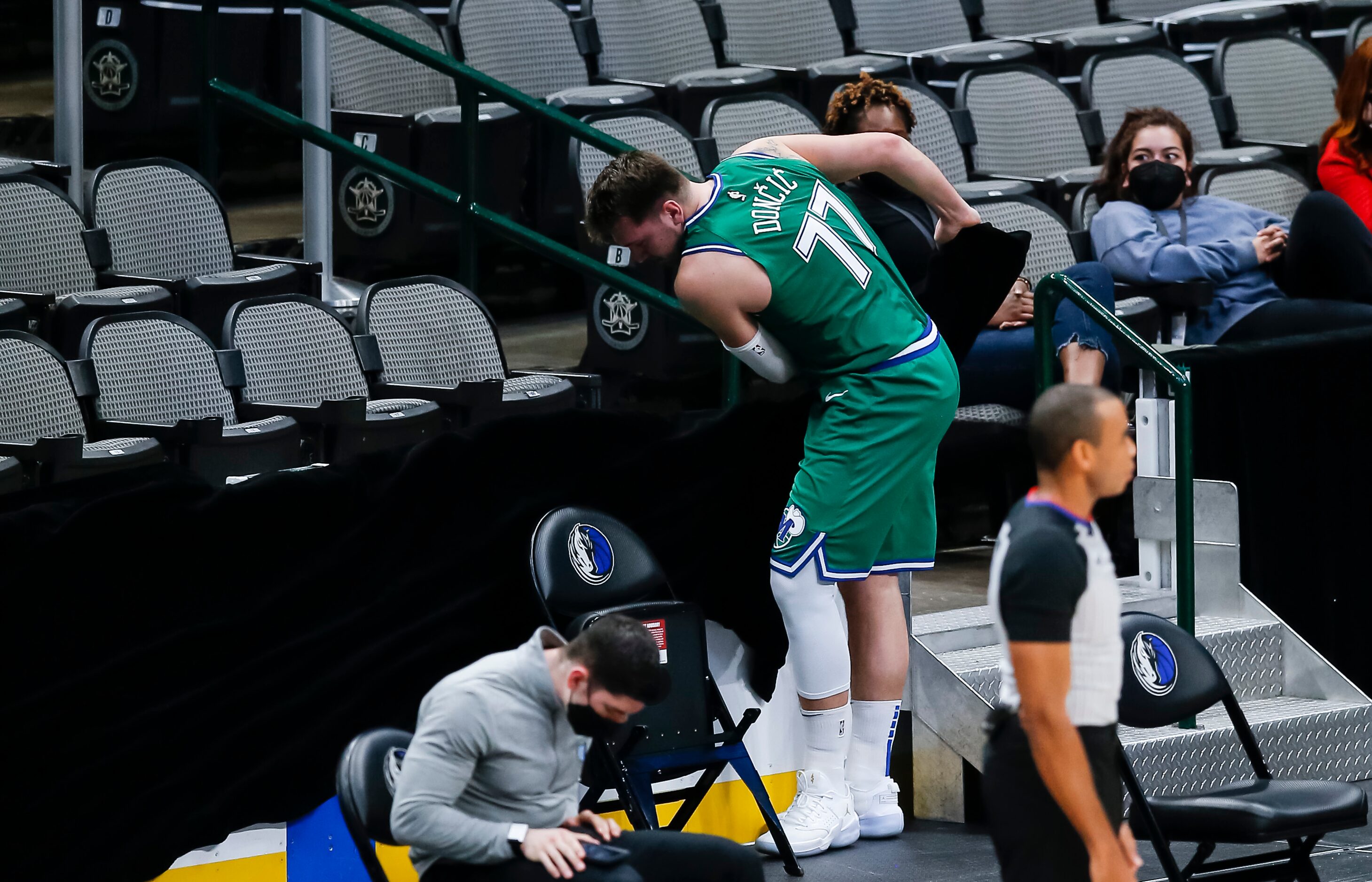 Dallas Mavericks guard Luka Doncic (77) rips off the black fabric covering the hockey boards...