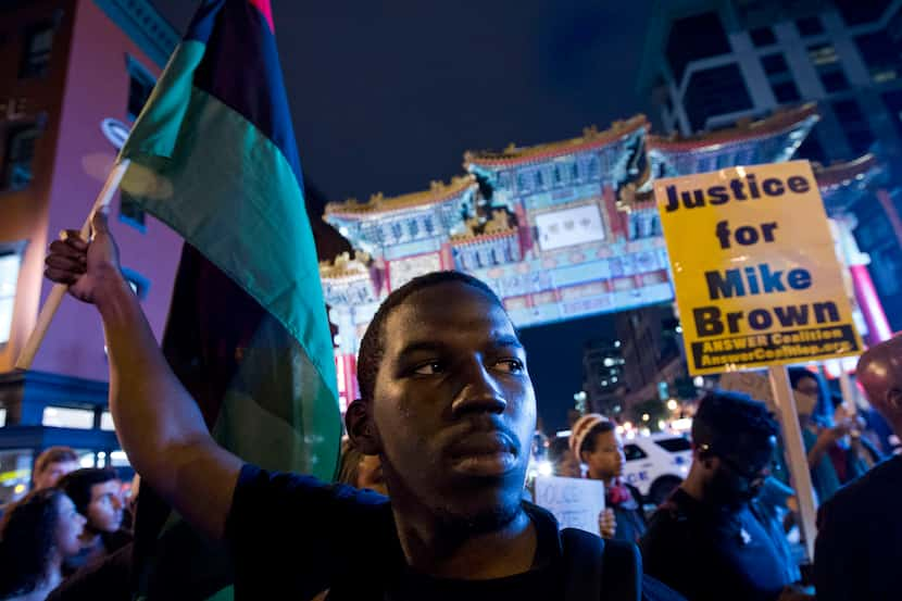 FILE - Demonstrators march through Chinatown during a protest against the shooting of...