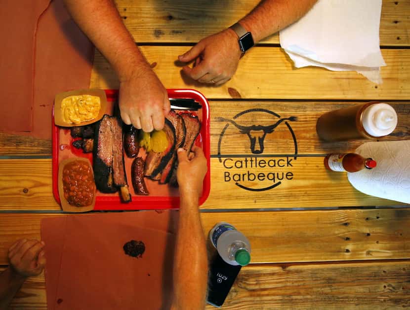 Diners dive into a tray full of burnt ends, brisket, beef rib, Texan spicy sausage, Italian...