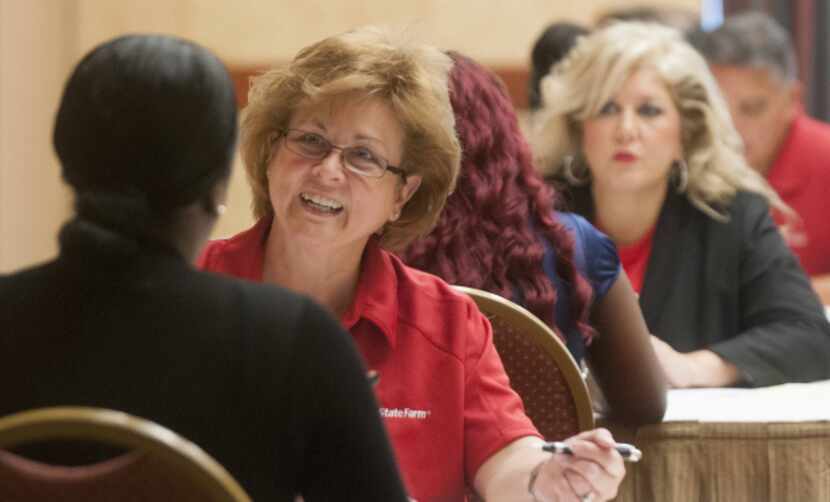 Carolyn Poling interviews a candidate during a State Farm Insurance job fair in Richardson....