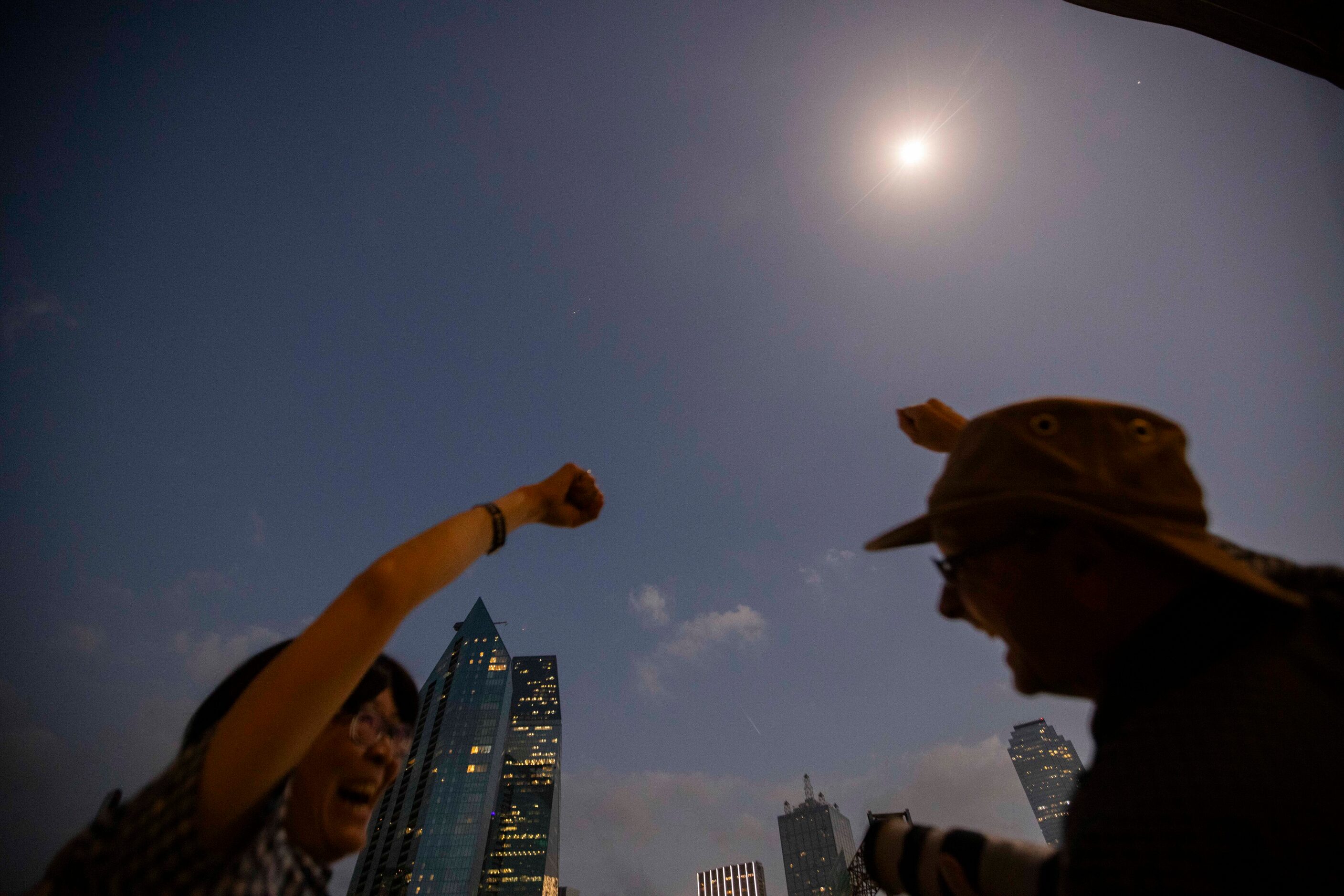 (From left) Lisa Kato and partner Hobson Bullman of Cambridge, UK cheer as totality ends...