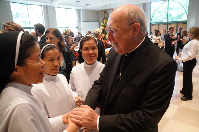Sisters Mary Ngo, Teresa Nguyen, and Teresa Bui congratulate Bishop Kevin Farrell after his...