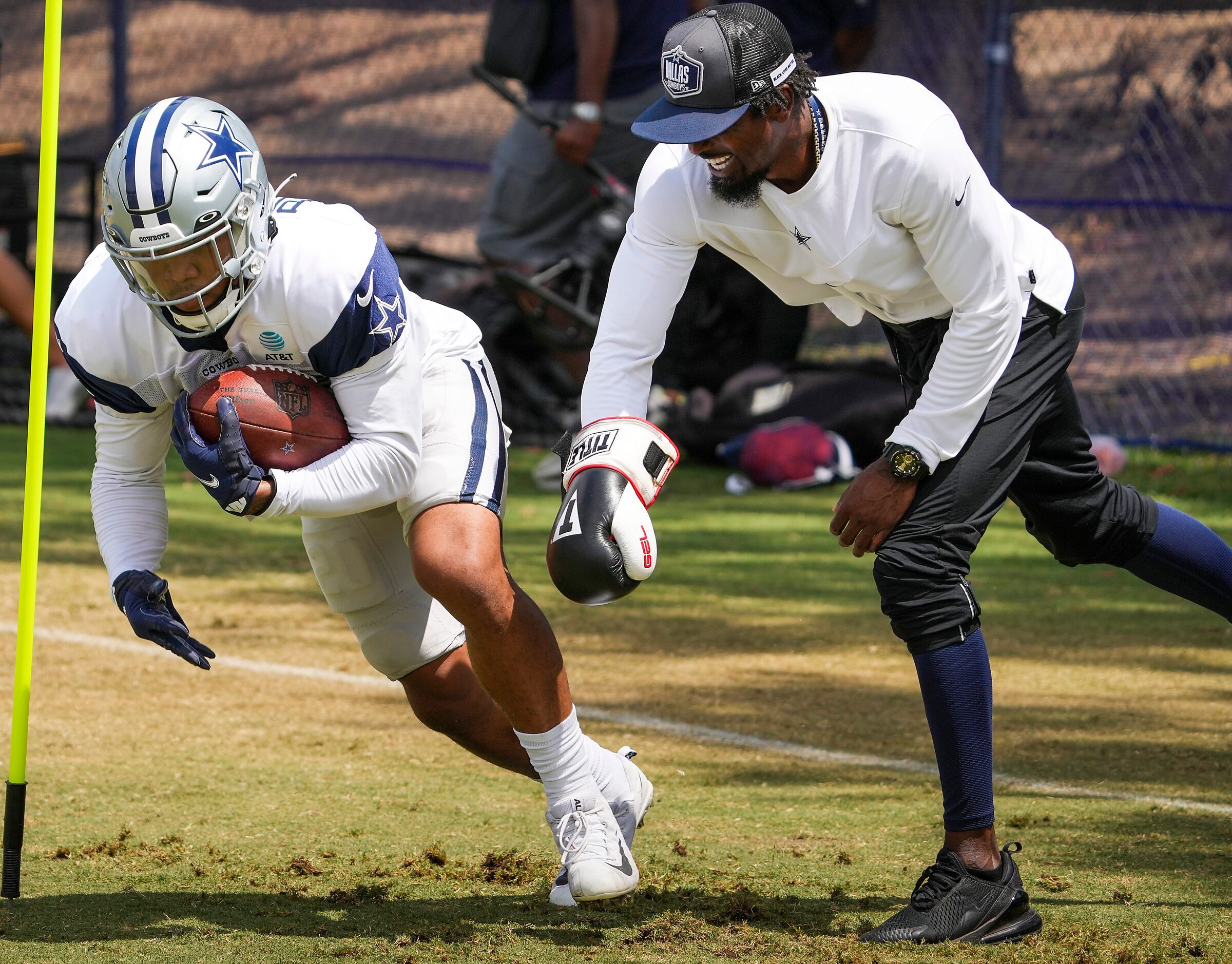 Dallas Cowboys defensive backs coach Al Harris tries to knock the ball away from  running...