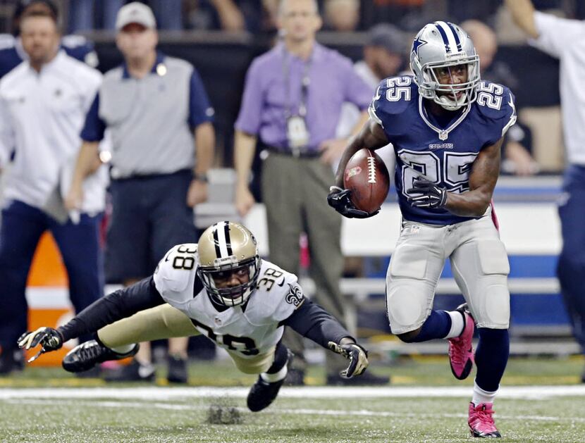 Dallas Cowboys running back Lance Dunbar (25) gets by a tackle attempt by New Orleans Saints...