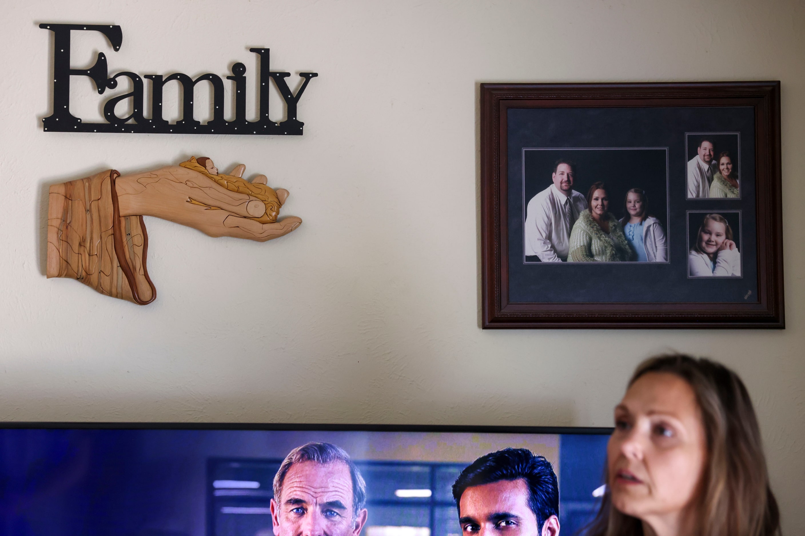 Amy Brewer stands in her Duncanville living room near a family photo of her daughter,...